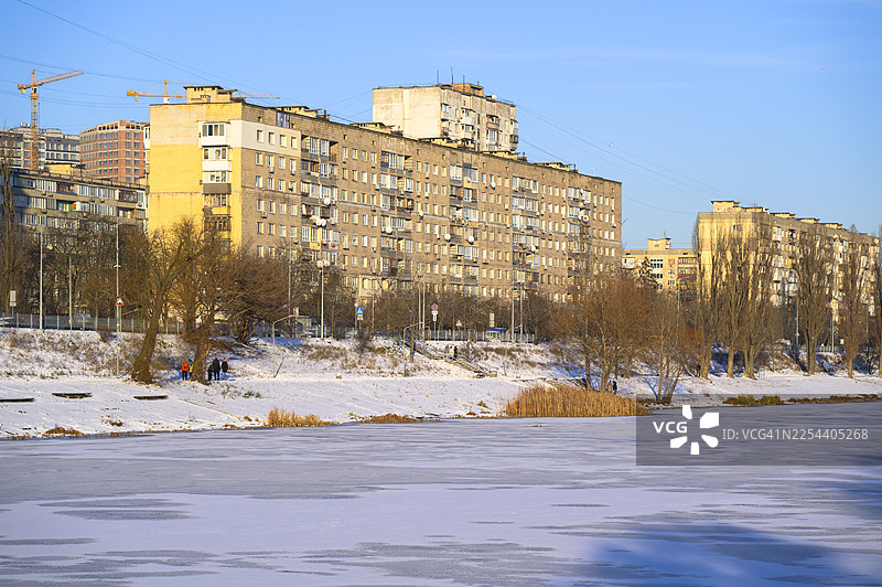 冬天，城市河流结冰，人们在河边散步图片素材