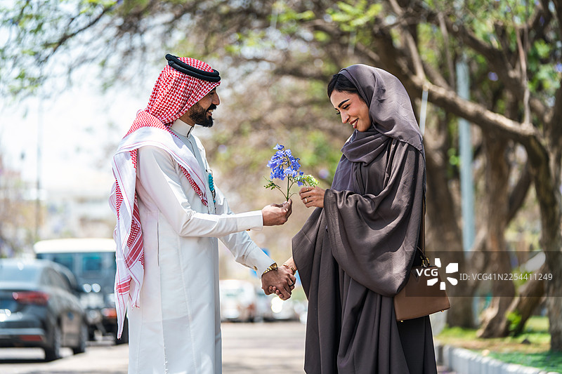 阿拉伯情侣在阿布哈公园享受紫楹花下的美好时光图片素材