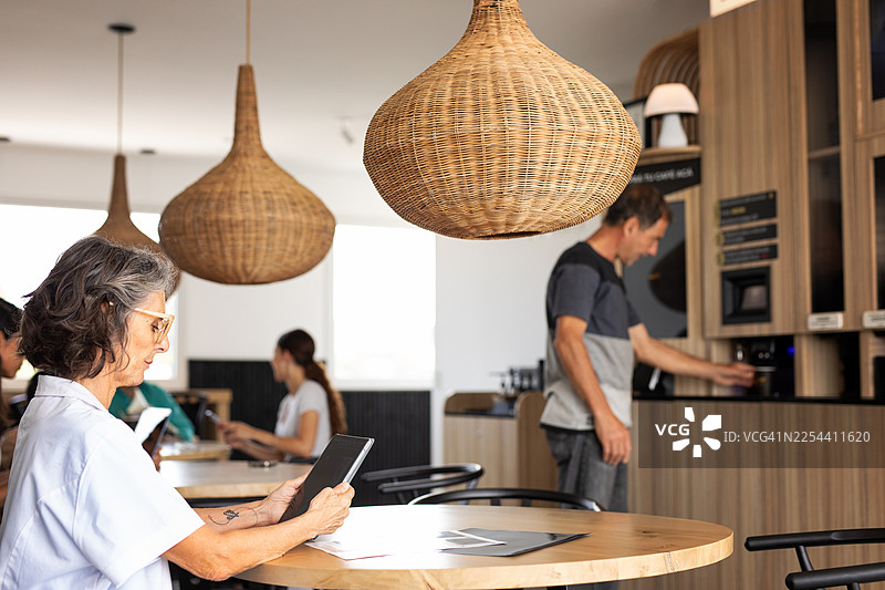 顾客在配备人工智能和机器人技术的全自动咖啡售货机上购买咖啡图片素材