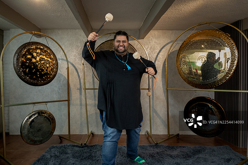 男子敲击铜锣进行声音疗愈，制造治疗性的振动，营造宁静的氛围图片素材