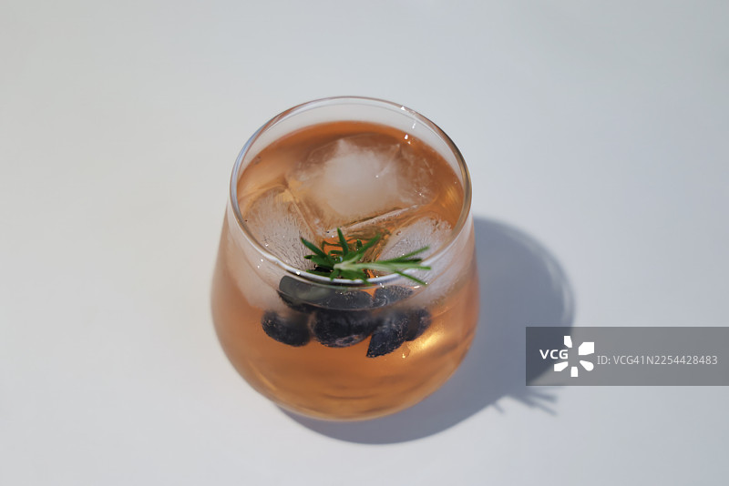 蔓越莓利口酒鸡尾酒，加入普罗塞克和苏打水，以蓝莓和迷迭香枝装饰图片素材