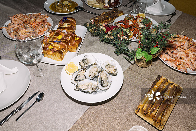 餐桌上的海鲜盛宴，有牡蛎、虾、龙虾、凤尾鱼和各种菜肴图片素材