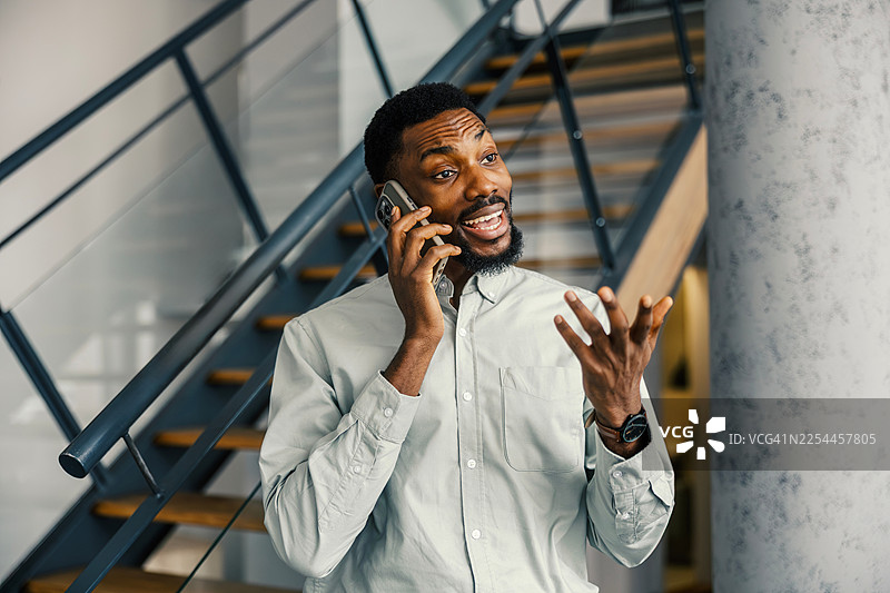 年轻成年男子正在进行一次情绪激动的电话交谈图片素材