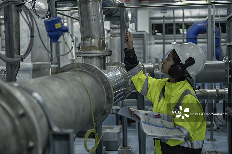 女工程师检查工业管道系统图片素材
