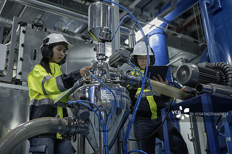 女工程师和男工程师操作工业加工设备图片素材