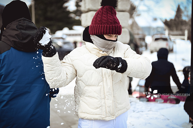 少女在冬季户外玩耍时扔雪球图片素材
