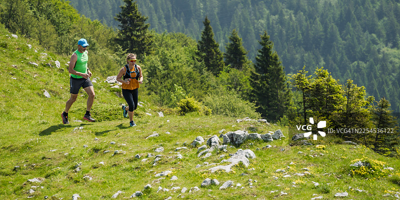 两名跑者在崎岖的山路上越野跑图片素材