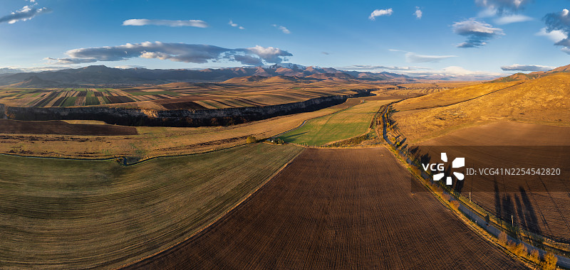 亚美尼亚洛里省的农田和村庄的鸟瞰图——日出后光线下的几何农田，背景为群山。图片素材