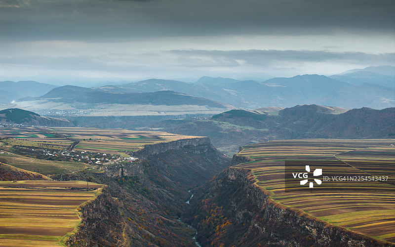 在广阔多云的天空下，德贝德峡谷的壮丽航拍全景图揭示了亚美尼亚洛里省的拼布田野和蜿蜒的河流。图片素材