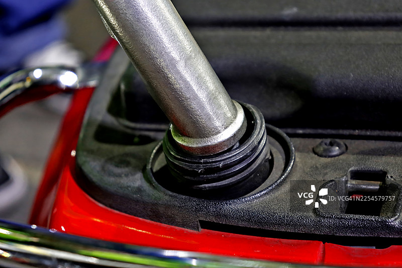 加油站特写：加油枪正在为摩托车油箱加注汽油图片素材