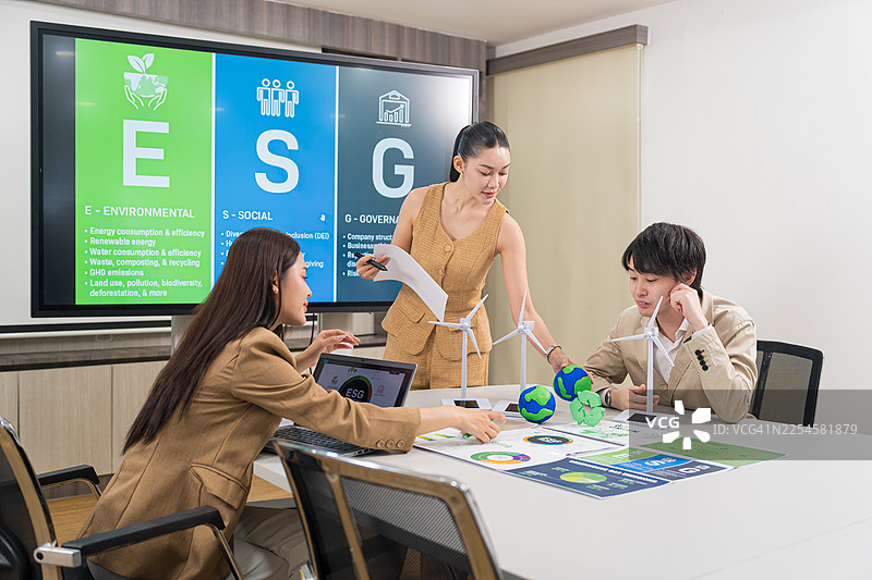一位女商人正在公司会议中展示绿色能源项目。图片素材