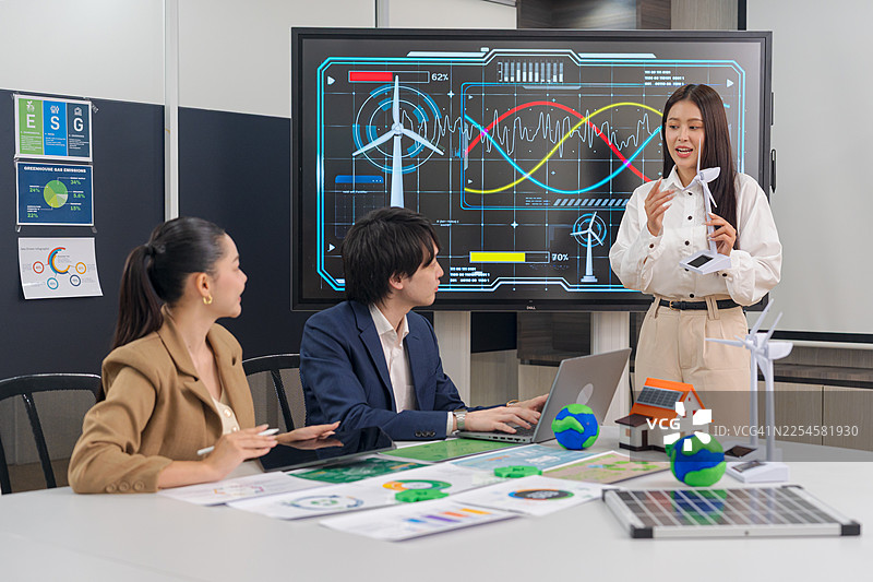 一位女商人正在会议上展示可持续能源解决方案。图片素材