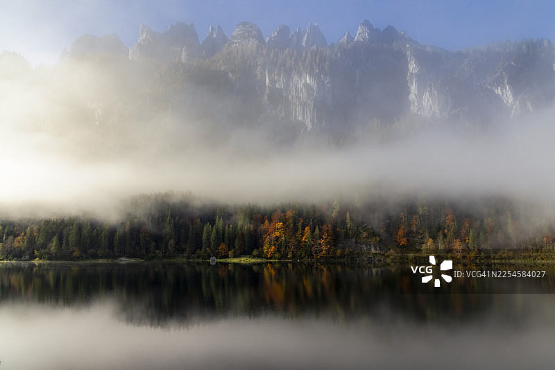 奥地利阿尔卑斯山戈绍湖的雾气弥漫的早晨。达赫斯坦山脉附近的奥地利阿尔卑斯山秋季景观。图片素材