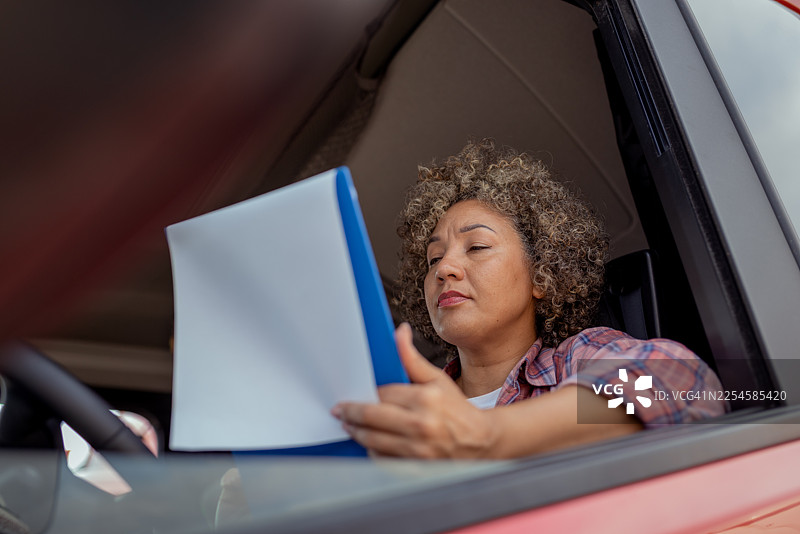 长途驾驶的女卡车司机在工作期间使用文件板图片素材
