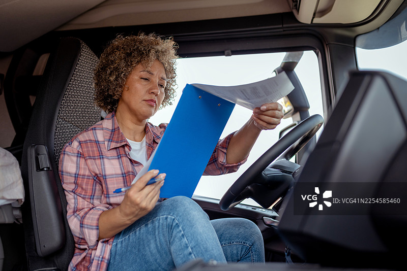 女卡车司机在休息时使用文件板图片素材