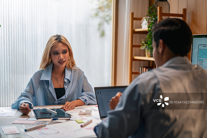 UX/UI设计师们正在讨论和集思广益，为网站和移动应用原型制作线框图图片素材