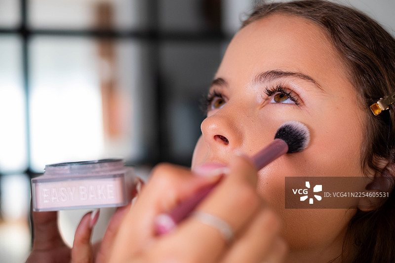 年轻女子在化妆过程中扑散粉图片素材