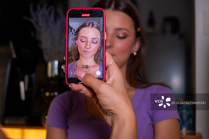 一位女士正在为社交媒体录制美妆教程视频图片素材
