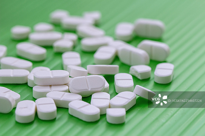 白色药片，绿色背景图片素材