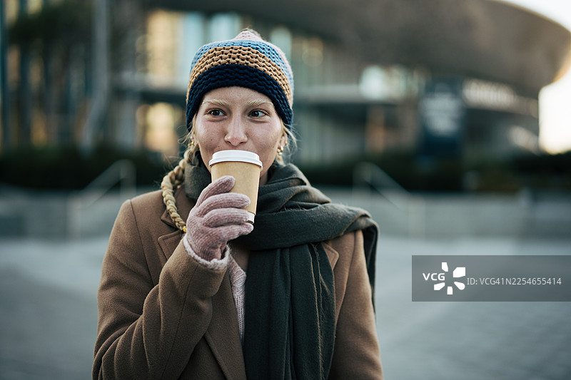 寒冷城市早晨，年轻女子享受热咖啡图片素材