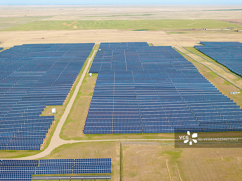 从空中俯瞰阿尔伯塔省布鲁克斯附近阳光明媚的草原上巨大的太阳能发电场图片素材