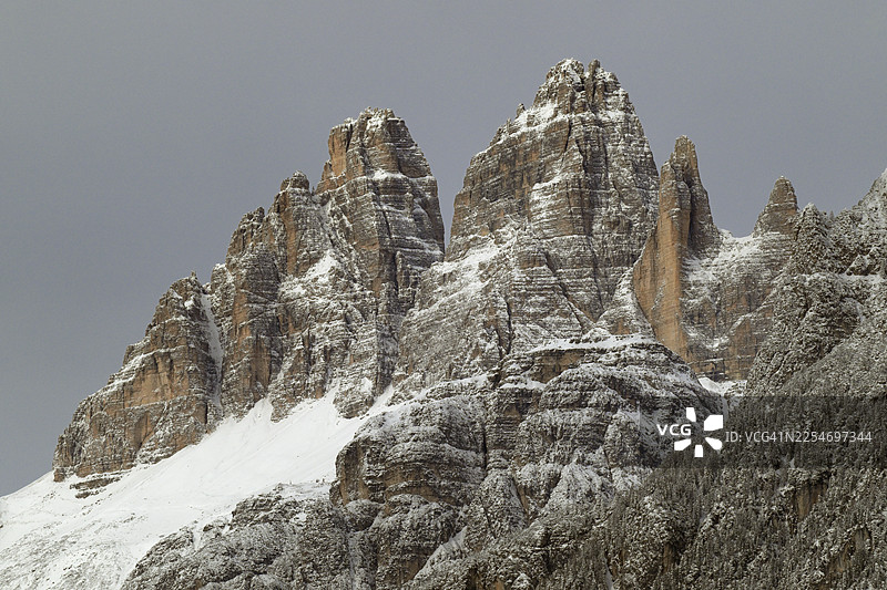 壮丽的雪山峰峦在灰色的冬季天空中升起，展现出崎岖的自然之美，意大利，三峰山图片素材