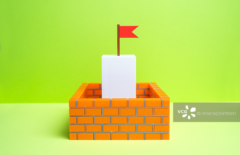 红旗插在砖墙结构白色方块之上，象征着成就与成功图片素材