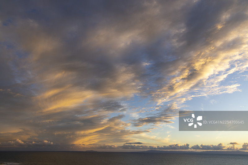 日落时分，海面上方金色云彩映衬下的戏剧性天空美景，美国，卡平特里亚图片素材