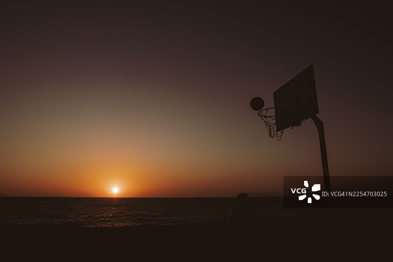 日落天空下的篮球架剪影图片素材