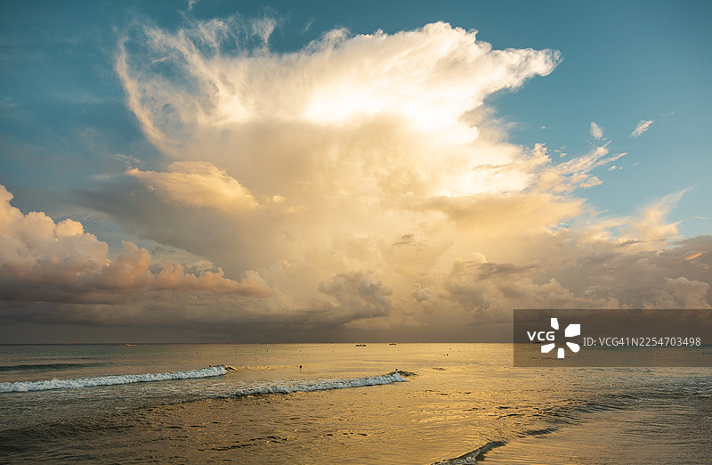 墨西哥普拉亚德尔卡曼，壮丽的日落映照在海面上，金色光芒洒满水面和云彩图片素材