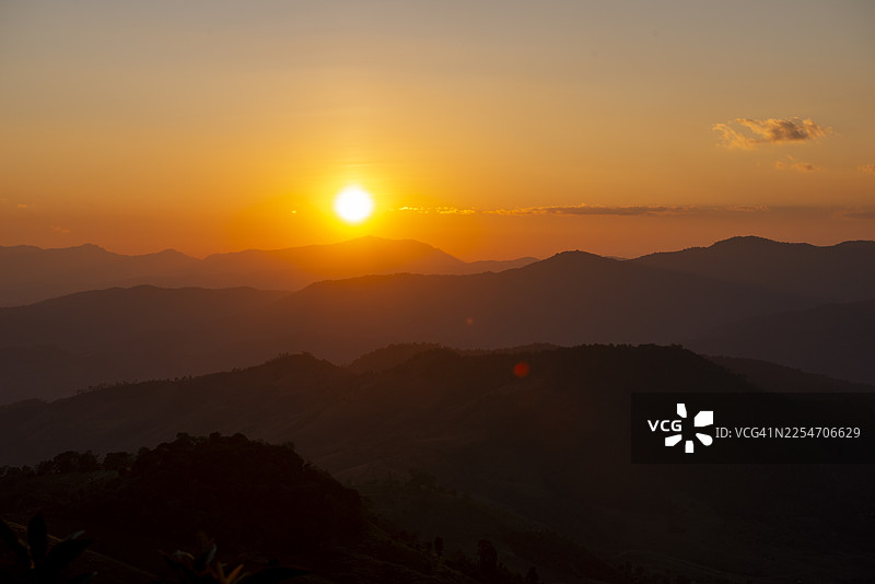 泰国清莱府昌岛的落日，余晖洒满连绵的山脊与山谷。图片素材