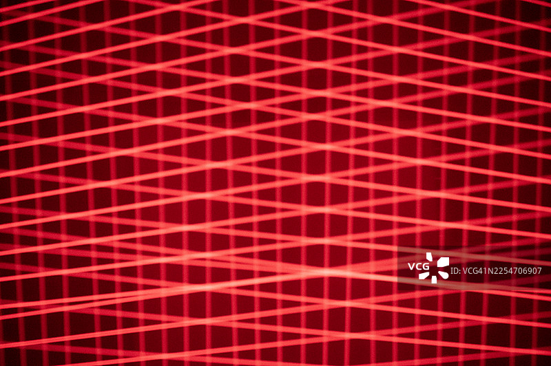 抽象的红色激光光束以图案交叉。图片素材
