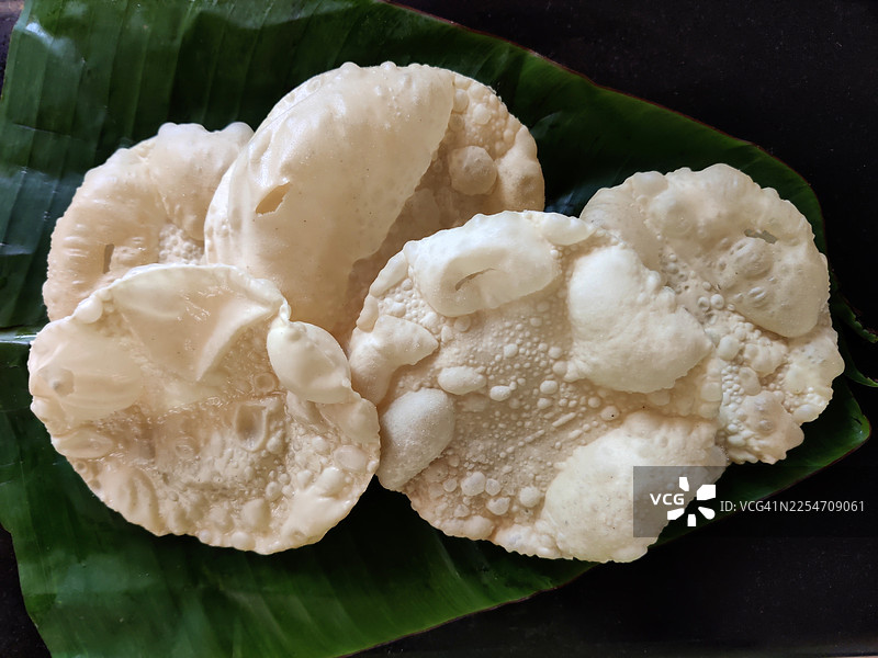 炸至酥脆的印度脆饼（也称为 papad 或 appalam），是一种薄而脆的扁平面包，盛放在芭蕉叶上，来自喀拉拉邦。图片素材