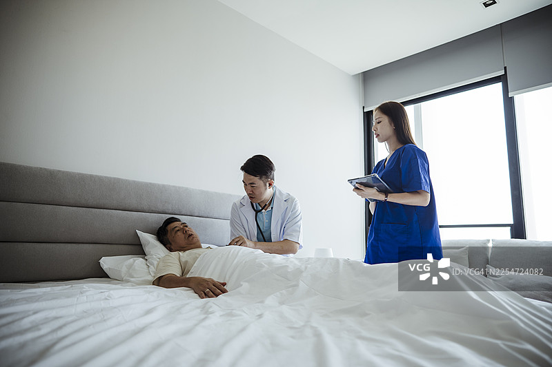 私立医院病房内，医生与病人进行医疗咨询图片素材
