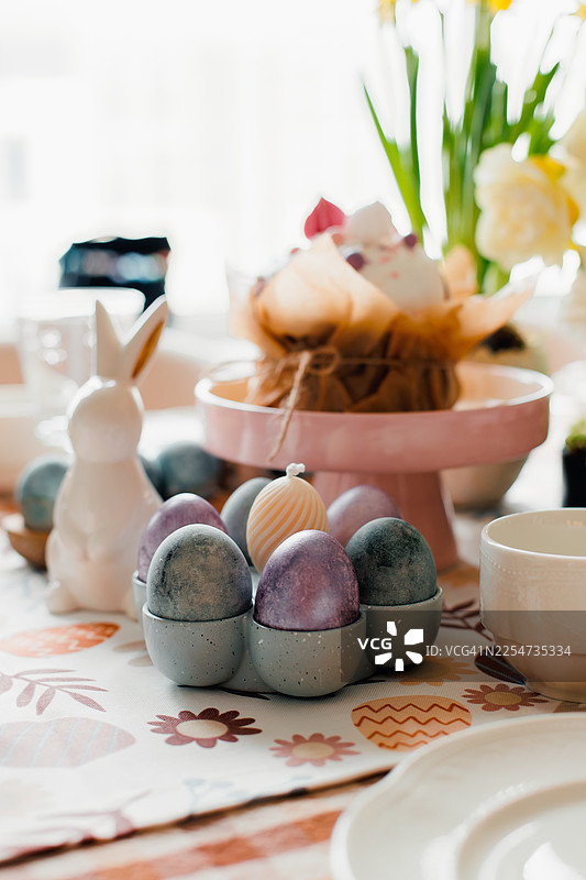 摆放着复活节糕点和节日装饰的时尚美观的桌子。复活节蛋糕，复活节彩蛋图片素材