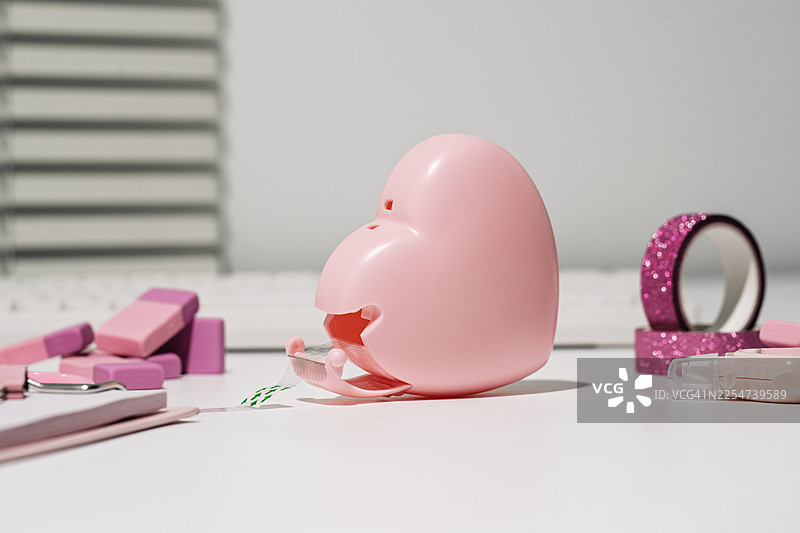 办公桌上的心形胶带座和其他粉色文具图片素材