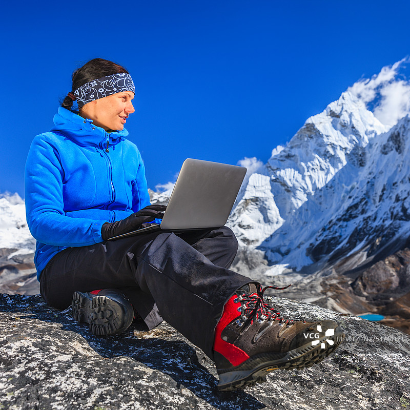 一位女士正在尼泊尔的珠穆朗玛峰国家公园使用笔记本电脑图片素材
