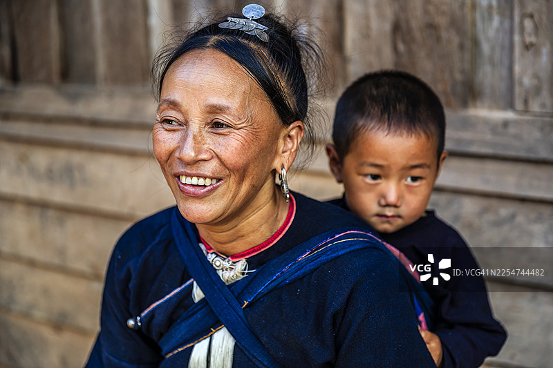 老挝母亲抱着她的小儿子，地点在老挝北部村庄图片素材