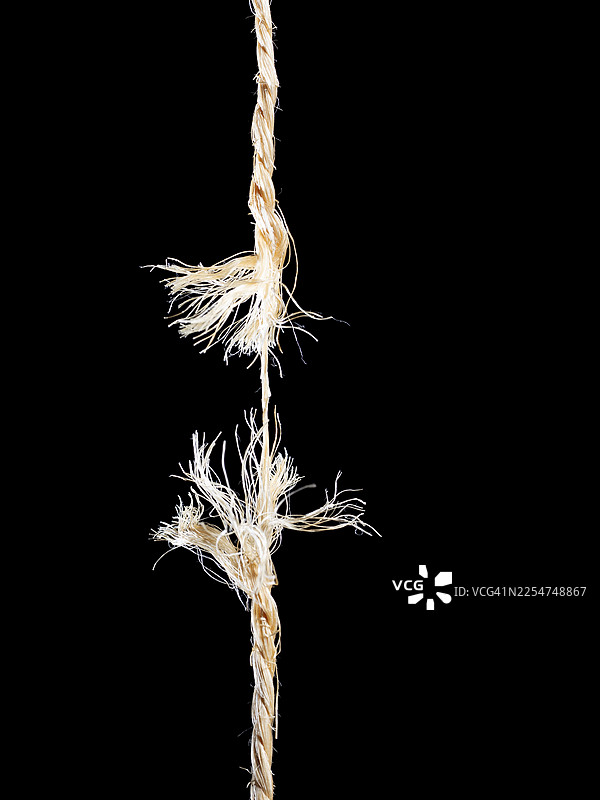 一根绳子在中间断裂，背景为黑色。图片素材