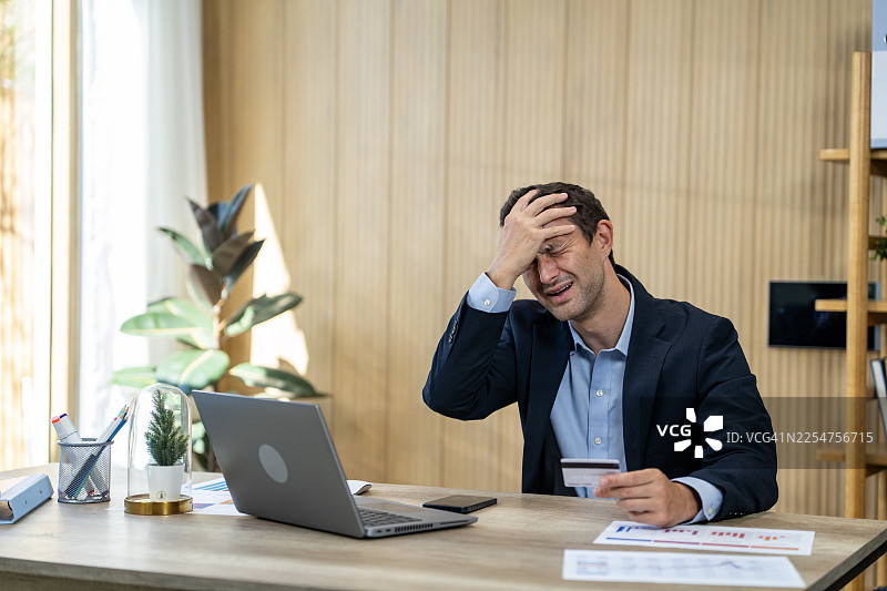 笔记本电脑上信用卡欺诈，一名压力山大的男子图片素材