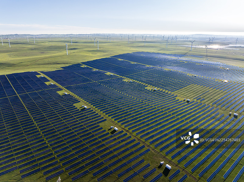 草原上的太阳能发电站和风力涡轮机图片素材