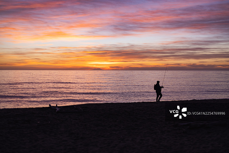 托斯卡纳阿尔贝雷塞海滩日落时的渔夫剪影图片素材