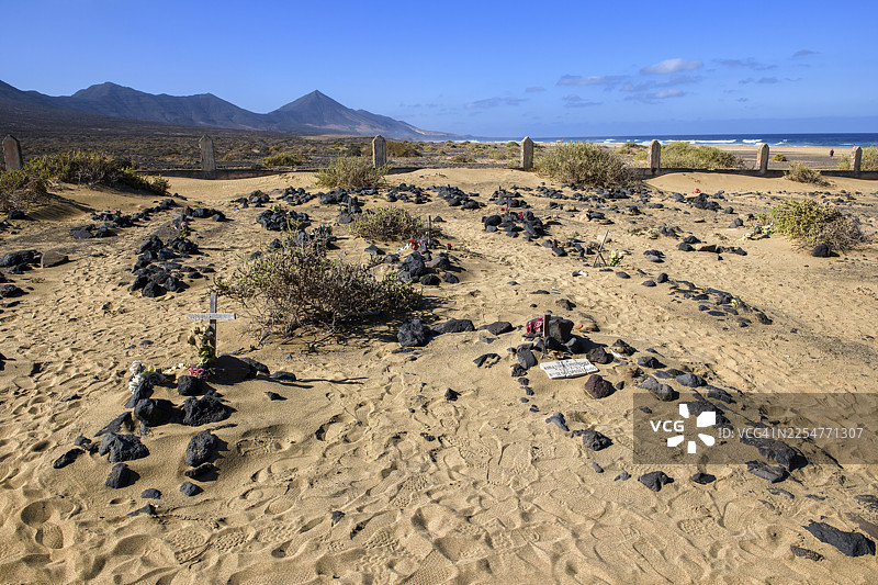 从1950年代被遗弃的科菲特村落的古老、风化的历史墓地看到的景象，有几座墓碑是用石头标记的，背景是大西洋，位于延达半岛西海岸的科菲特，延达，富埃特文图拉省拉斯帕尔马斯图片素材