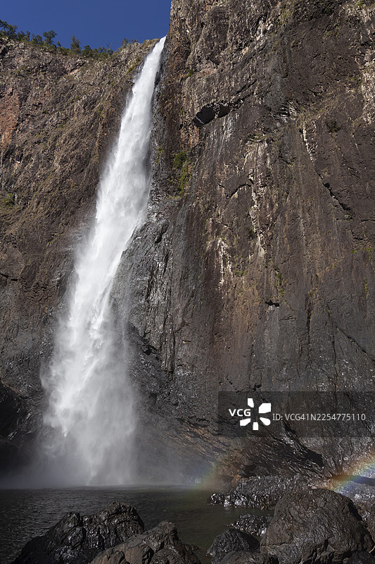 从下方仰视的白特曼瀑布白天景色，瀑布倾泻而下汇入澳大利亚昆士兰州的热带雨林峡谷。图片素材