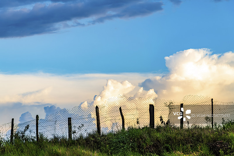 巴西米纳斯吉拉斯州欧鲁普雷图农场，日落时分山顶上的铁丝网图片素材