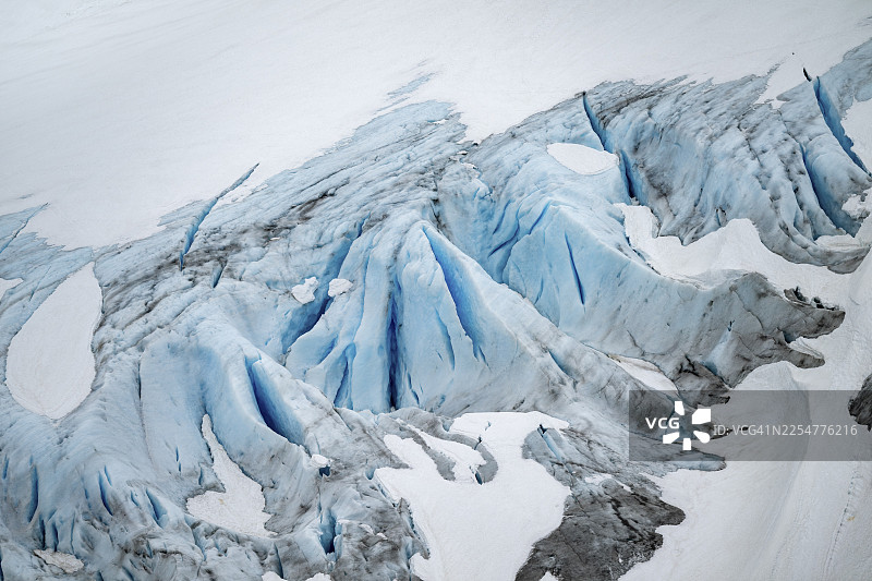 阿拉斯加肯纳半岛出口冰川的蓝色粗糙冰川，有冰裂缝和积雪，特写图片素材