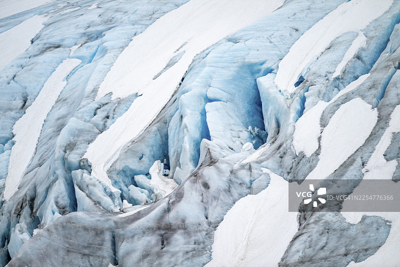 阿拉斯加肯纳伊半岛出口冰川的蓝色崎岖冰川冰，带有冰裂缝和积雪，细节图片素材