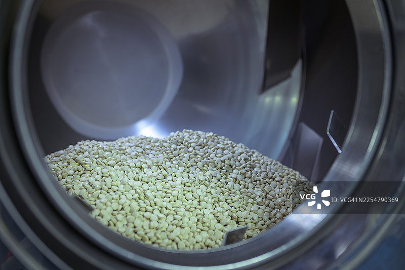 制药厂的包衣机中的药物片剂图片素材