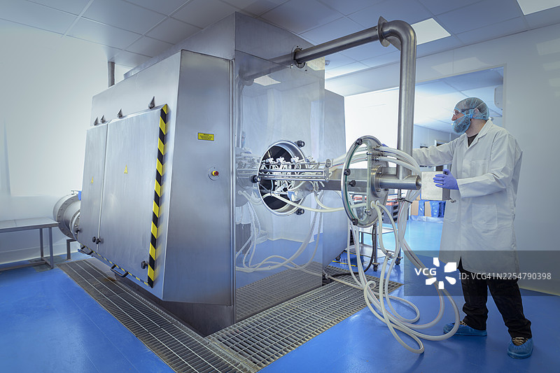 制药厂的操作员正在操作药片包衣机图片素材