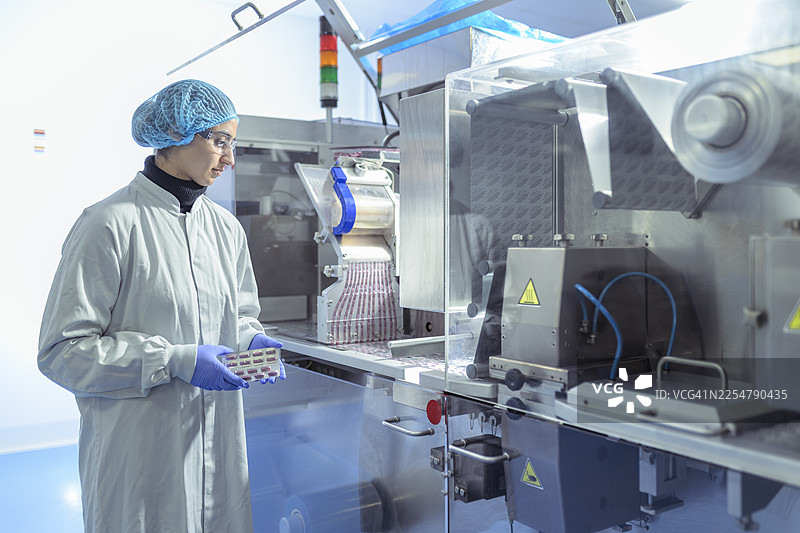 制药厂工人正在检查药品泡罩包装的成品图片素材